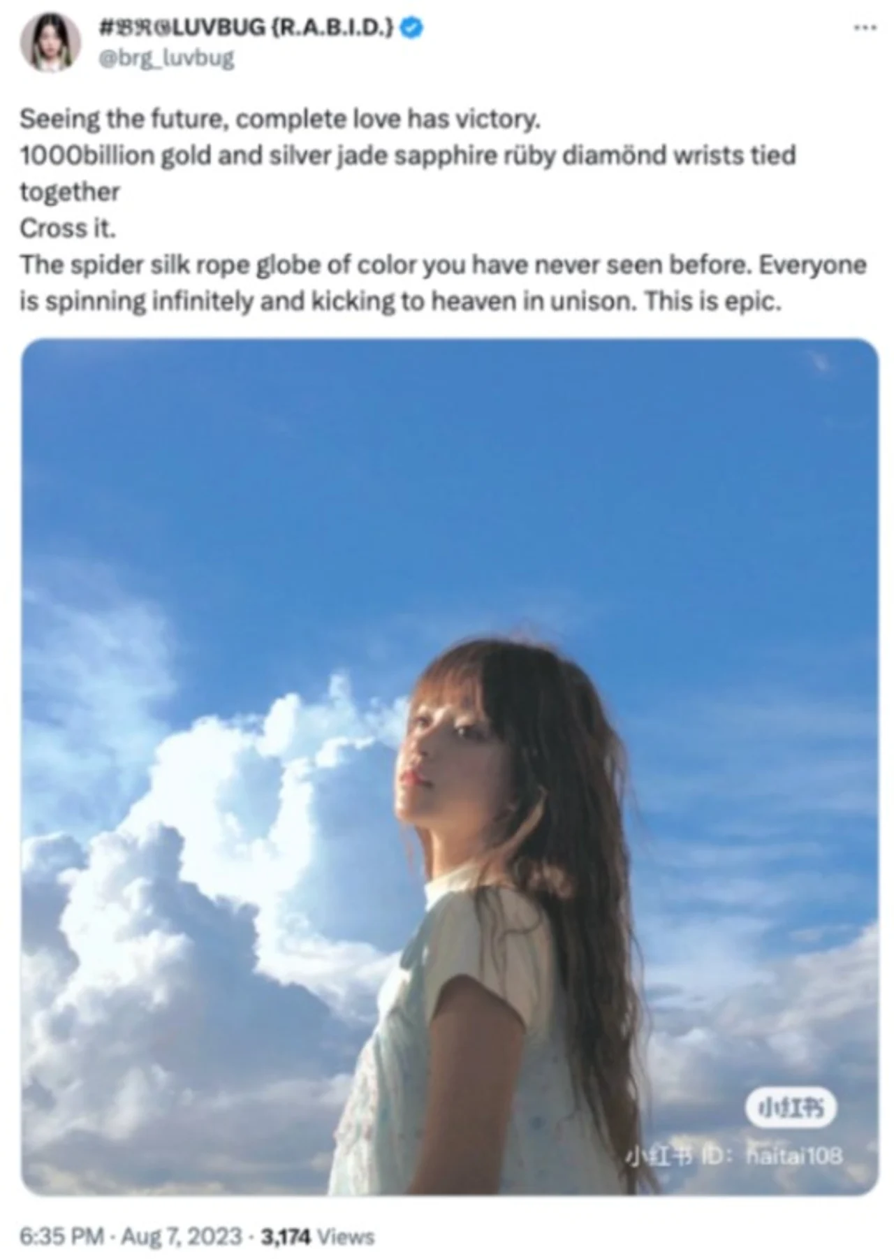 Screenshot of a tweet with surreal poetic text above a photo of a long-haired girl against blue sky and clouds