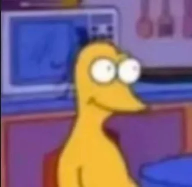 Blurry cartoon screenshot of a bald yellow character with bulging eyes smirking in a kitchen